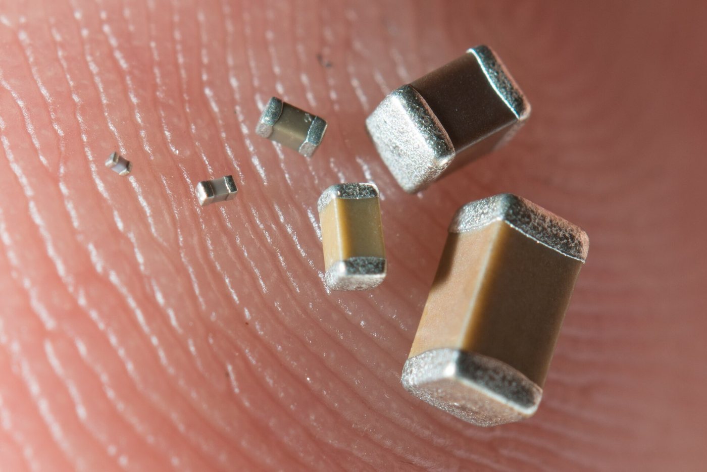 Six SMD capacitors on a fingertip